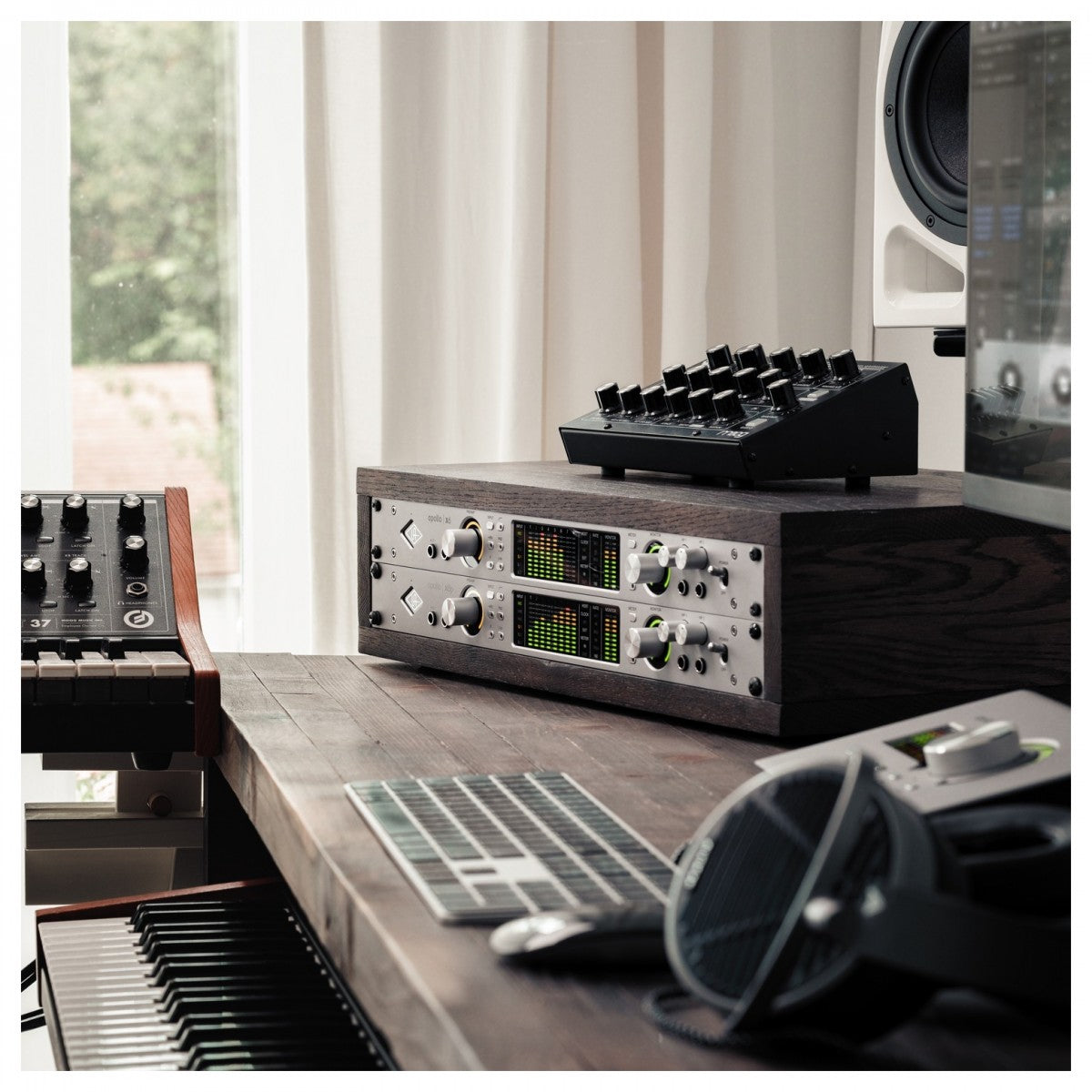 Music production equipment, including Universal Audio Apollo x8 on a desk.