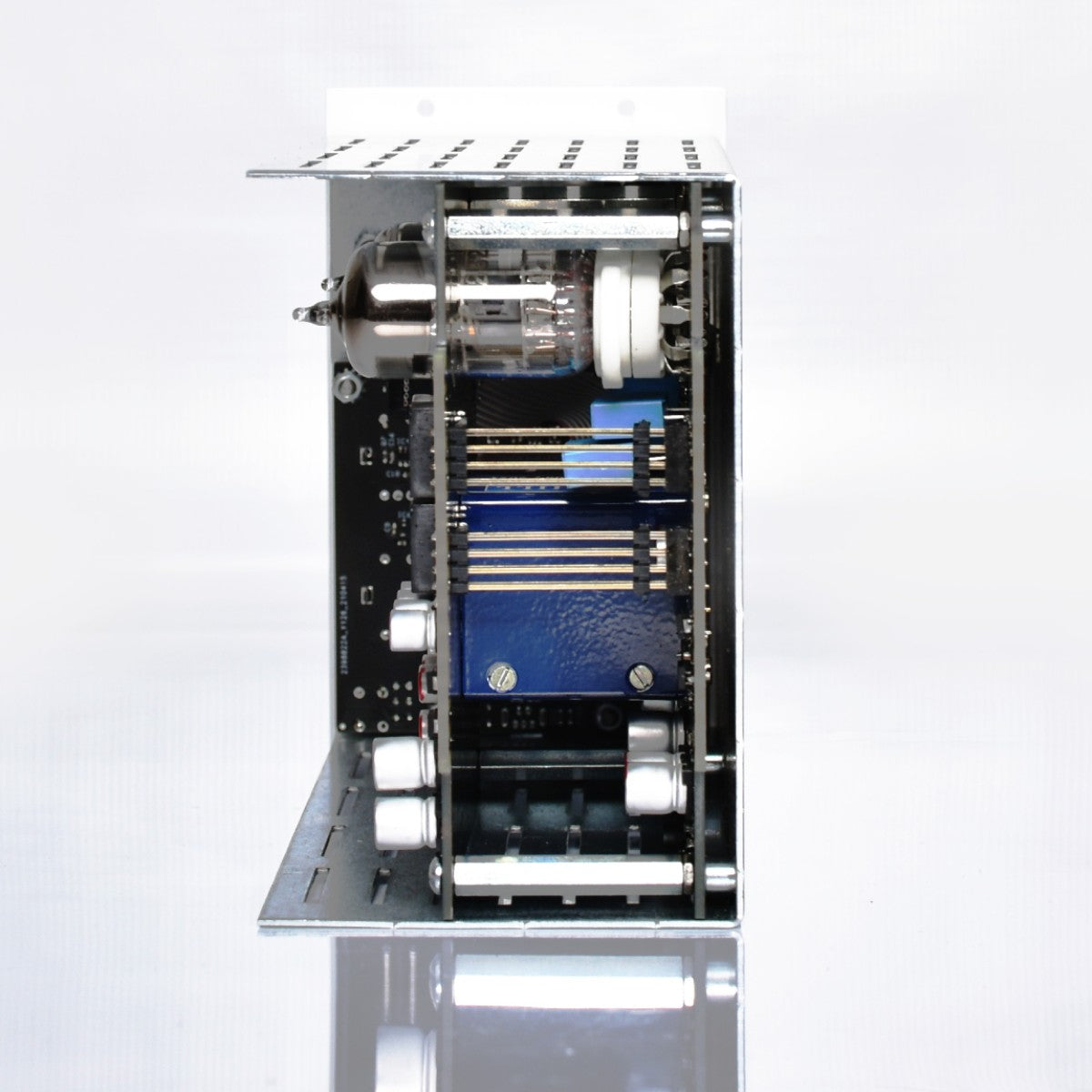 An open metal electronic chassis showing internal components including a vacuum tube, circuit boards, and capacitors, set against a clean white background with a reflection below.